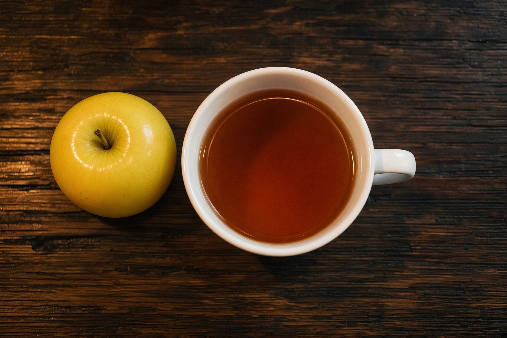Black tea beside a yellow apple